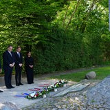 Vor dem Denkmal am U-Boot-Bunker Valentin stehen drei Frauen und ein Mann und gedenken vor niedergelegten Kränzen.