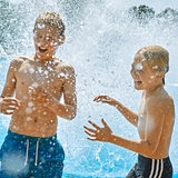 2 Jungen in einer Wasserfontäne im Bremer Schlosspark Freibad