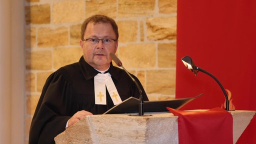 Ein Friedensbeauftragter aus Bremen bei einer Predigt in der Kirche. 