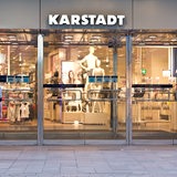 Der Eingang der Bremer Karstadt-Filiale. Im Vordergrund läuft ein junger Mann. Über der Tür steht "Karstadt".