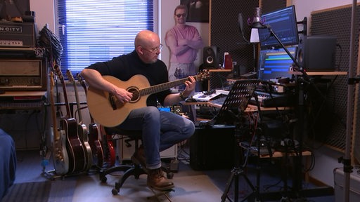 Der Bremer Martin Olding spielt Gitarre in einem Studio.