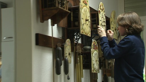 Lucas Ruppert stellt als Junge die Zeiger einer antiken Uhr ein 