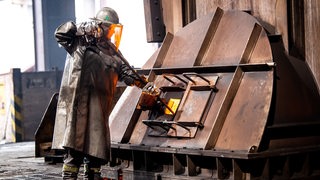 Ein Arbeiter im Schutzanzug im Bremer Stahlwerk