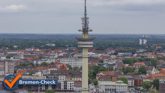 Ein hoher Fernsehturm erhebt sich überdie Stad Bremerhaven mit zahlreichen Gebäuden, der Himmel ist leicht bewölkt,