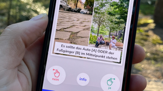 Eine Hand hält ein Smartphone mit zwei Fotos.