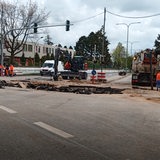 Baurarbeiter arbeiten in einer Baustelle an einer aufgerissenen Straße.