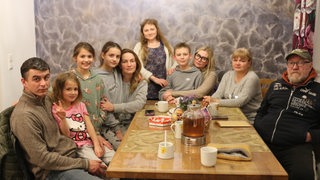 Eine geflüchtete Familie aus der Ukraine sitzt am Küchentisch von Taisa Zieske in Bremerhaven