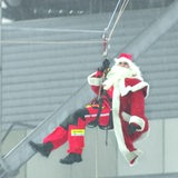 Eine Person im Nikolaus-Kostüm hängt in den Seilen.