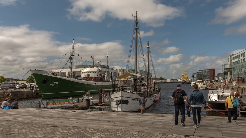 Im Bremerhavener Fischereihafen betrachteten mehrere Menschen die festgemachten Schiffe.