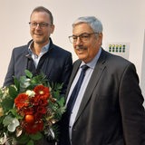 Bremerhavens Oberbürgermeister Melf Grantz übergibt einen Blumenstrauß an Stadtrat Martin Günthner.