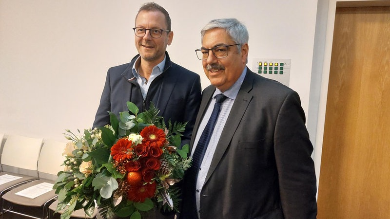 Bremerhavens Oberbürgermeister Melf Grantz übergibt einen Blumenstrauß an Stadtrat Martin Günthner.