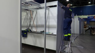 Ein Techniker beim aufbauen einer Impfkammer des neuen Impfzentrums in Bremerhaven. 