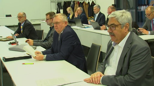 Der Bremerhavener Bürgermeister und Bremerhavens Stadtkämmerer sitzen nebeneinander bei der Stadtverordnetenversammlung. 