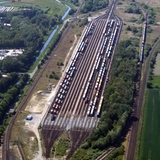 Eine Luftaufnahme zeigt mehrere Gleise nebeneinander in einer grünen Landschaft.