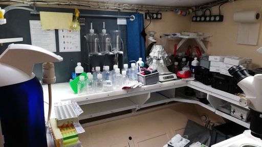 In einem kleinen Labor stehen Behälter und Geräte.