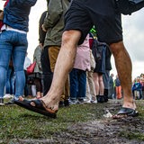 Matschige Füße in Sandalen laufen über den triefenden Boden am Osterdeich