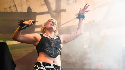 Sängerin der Band Flirt auf der Breminale-Bühne mit Händen in der Luft