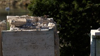 Ein kaputter Betonsockel auf einem Friedhof