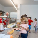 Kinder stehen am Buffet und nehmen sich Frühstück