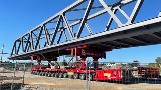 Eine Brücke liegt auf einem Tieflader auf.