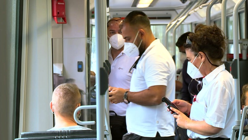 Mehrere Kontrolleure der BSAG stehen in einer Straßenbahn.