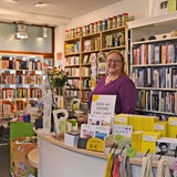 Eine Frau steht hinter einer Theke in einem Buchladen.
