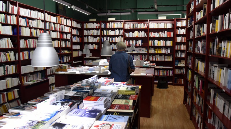 Ein Mann steht in einer Buchhandlung.