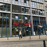 Einige Menschen laufen vor dem BürgerServiceCenter in Bremen auf der Straße entlang