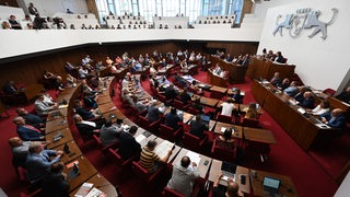 Abgeordnete sitzen im Sitzungssaal der Bremischen Bürgerschaft.