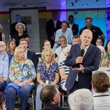 Bundeskanzler Olaf Scholz steht während eines Bürgerdialogs an einem Rednerpult.