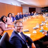 Das gesamte Bundeskabinett sitzt an einem Tisch.