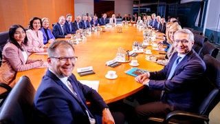 Das gesamte Bundeskabinett sitzt an einem Tisch.