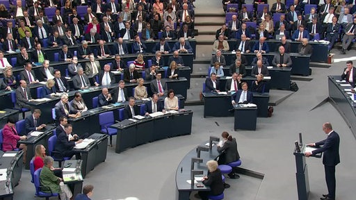 Eine Sitzung im Bundestag, in welcher Friedrich Merz am Rednerpult eine Rede hält.