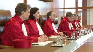 Die Mitglieder des Bundesverfassungsgerichts im Fall der Hartz-IV-Sanktionen nebeneinander sitzend.