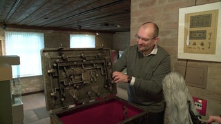 In der Burg Bederkesa zeigt ein Mann den Schließmechanismus einer Schatztruhe.