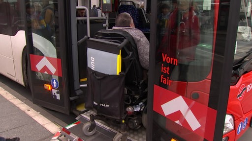 Ein Rollstuhlfahrer steigt in einen Bus ein