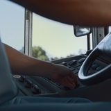 Ein Busfahrer von unten im Cockpit