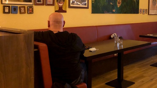 Ein Kunde sitzt allein in einem Café 