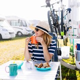 Eine Frau mit Hut und Sonnenbrille bei einem Frühstück auf einem Campingplatz (Symbolbild)