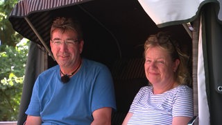 Die Campingplatz Besitzer Thomas und Barbara Schweder sitzen in einem Strandkorb.