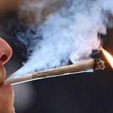 Junger Mann raucht einen Joint