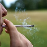 Ein Mann zieht an einem Cannabis-Joint.