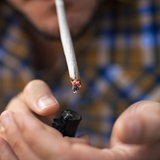 Mann zündet Marihuana-Zigarette mit Feuerzeug an (Symbolbild)