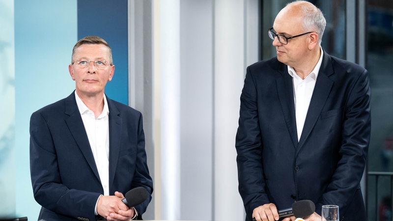 Andreas Bovenschulte (rechts), Spitzenkandidat der SPD in Bremen, und Frank Imhoff, Spitzenkandidat der CDU in Bremen stehen nach der Wahl in einem Fernsehstudio nebeneinander.