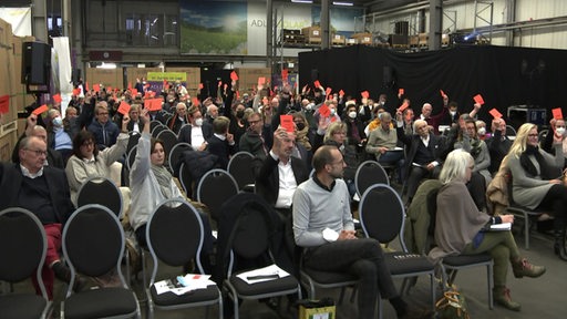 Die Bremer CDU hält einen Klimaparteitag ab. Die Abgeordneten stimmen mit roten Kärtchen ab und halten sie hoch.