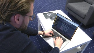 Eine Person tippt im Laptop Fragen für die AI Chat GPT Seite. 