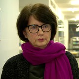 Eine Frau, Claudia Bernhard, blickt in eine Kamera.