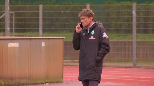 Der Sportchef Clemens Fritz am telefonieren auf dem Trainingsplatz. 