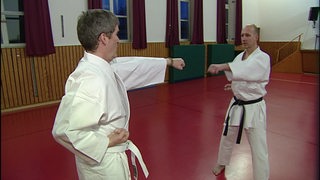 Reporter steht beim Karate-Training auf der Matte