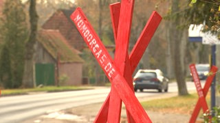 ein rotes Kreuz vor einer Straße